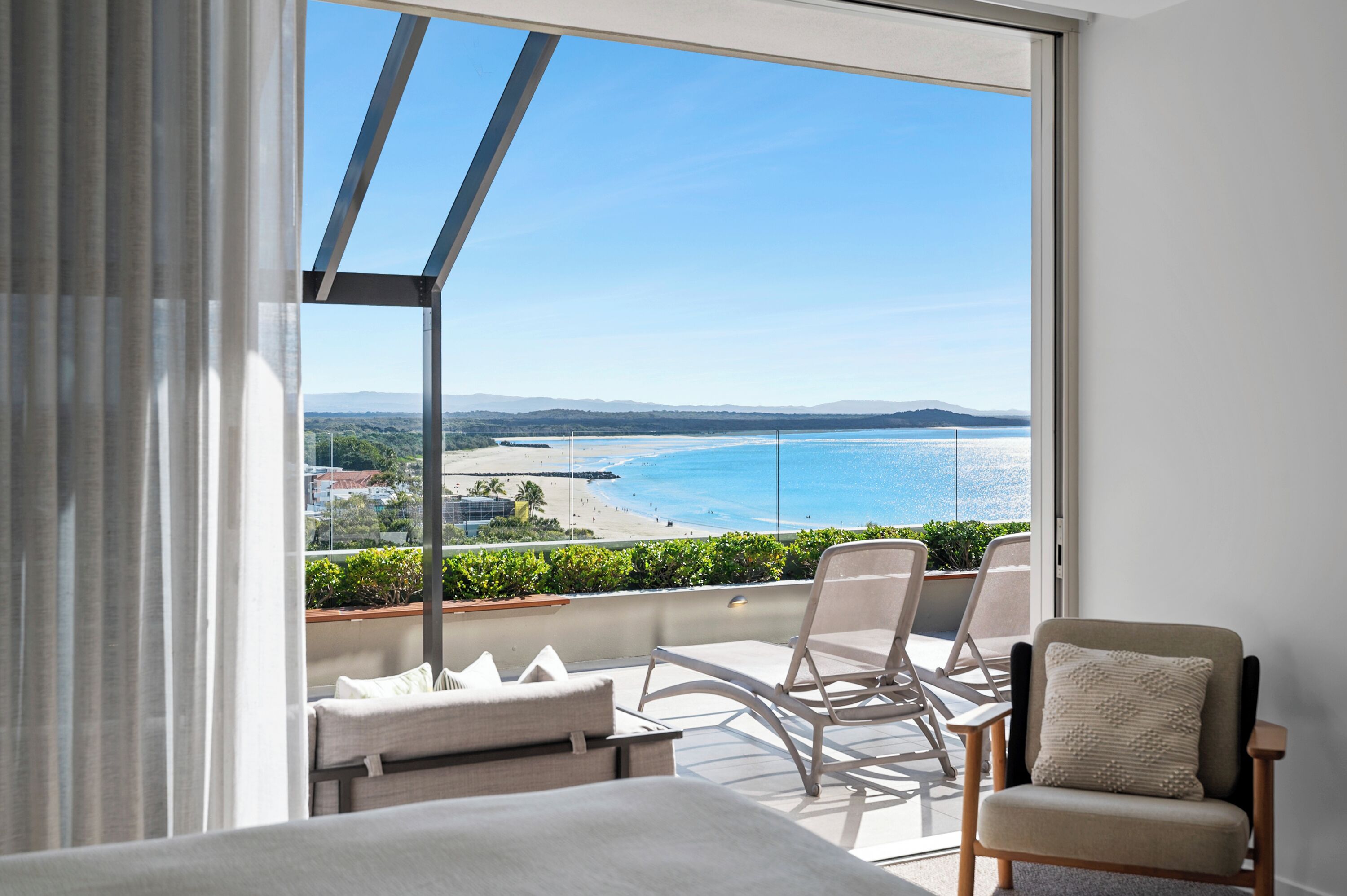 A balcony with a view of a beach and ocean.