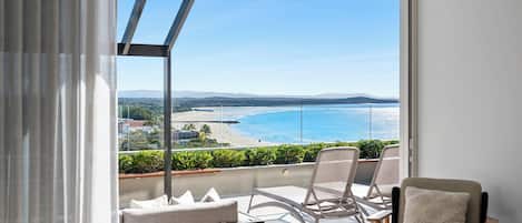 A balcony with a view of a beach and ocean.