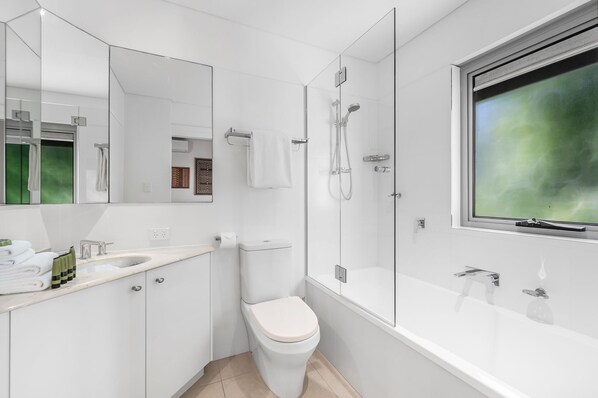 Une salle de bain moderne équipée de toilettes, d’un lavabo et d’une douche.