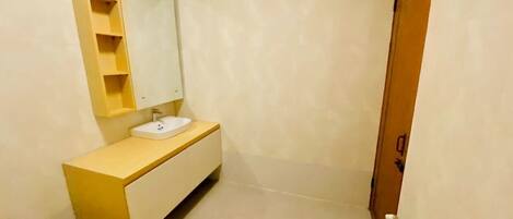 A modern bathroom with a wooden vanity, a sink, and a toilet.