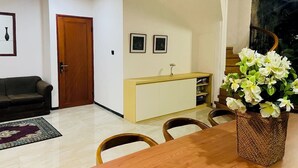 Un salon comprenant une table à manger en bois, des chaises, un canapé et un meuble.