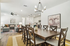 Una sala moderna con comedor, cocina y ventilador de techo.