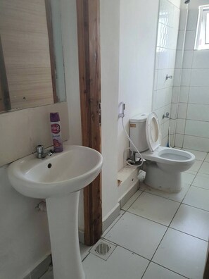 Een douche, handdoeken, zeep, toiletpapier