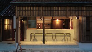 A traditional Japanese building with a reception desk, wooden exterior, and a tiled roof. - Komado Bengara (Komatsu)