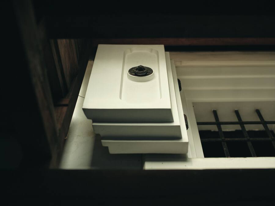 A white stove with a control panel, located in a kitchen with a wooden cabinet and a white countertop.