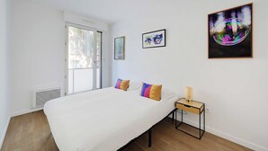 Ein Schlafzimmer mit einem Bett, einem Nachttisch, einem Heizgerät und einem Fenster.
