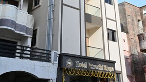 A multi-story hotel with a modern design, featuring balconies and a prominent entrance with signage. - Ravechi Krupa Hotel (Dwarka)