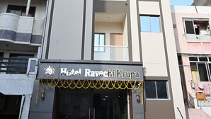 A tall hotel building with a reception area at the ground level. - Ravechi Krupa Hotel (Dwarka)