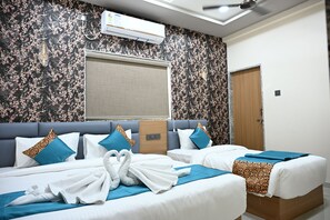 A hotel room with two beds, a large window, an air conditioning unit, and a ceiling fan.