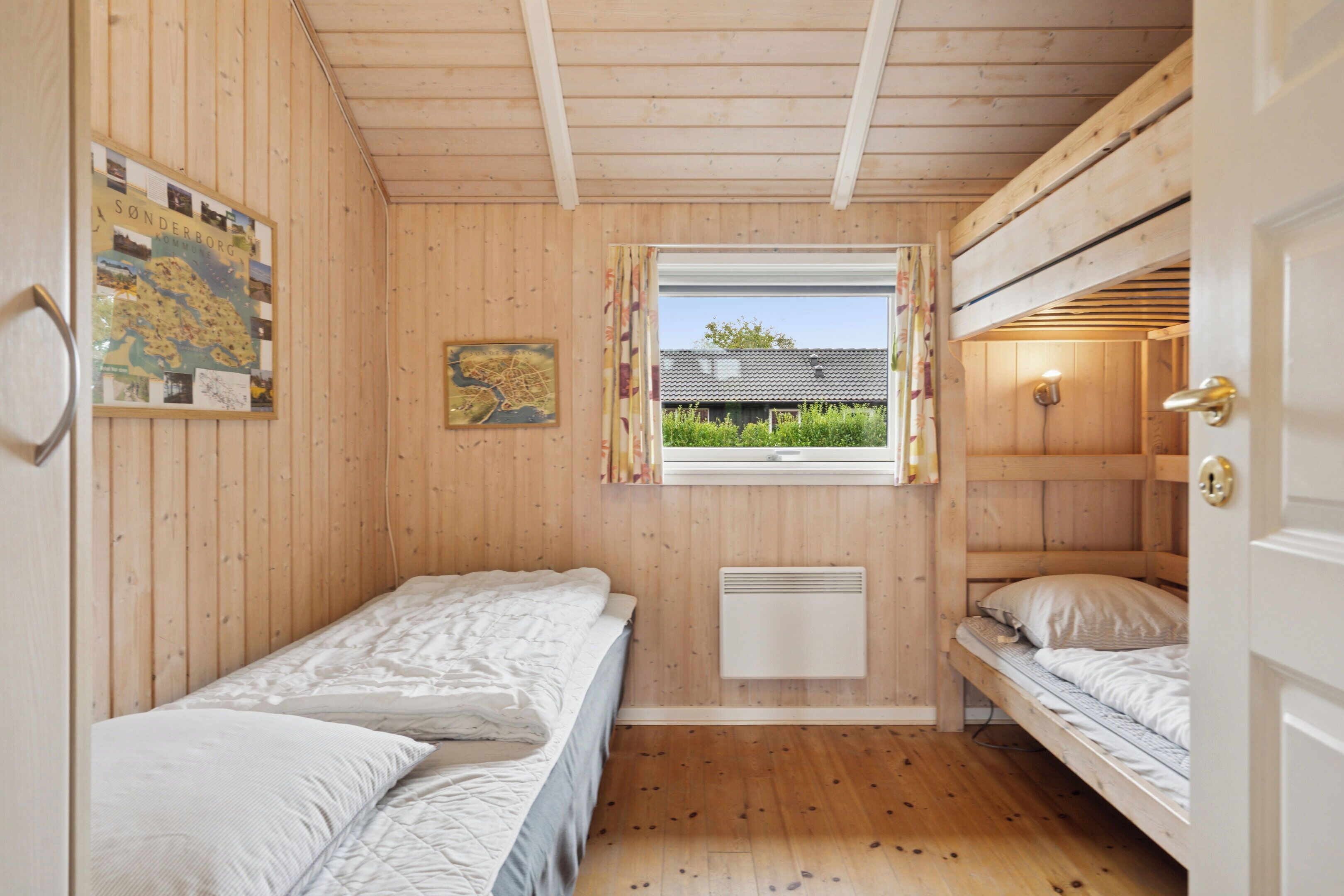 Eine Holzhütte mit Etagenbetten, einem Fenster mit Blick und einer Karte an der Wand.