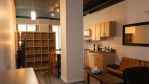 Een moderne keuken met houten kasten, een eethoek met een tafel en stoelen, en een zithoek met een bank en salontafel.