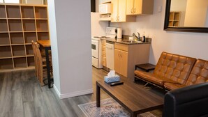 Een moderne keuken met een eethoek, een bank en een boekenkast.