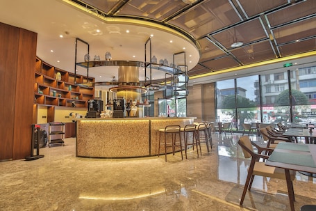 A modern bar area with a curved counter, seating, and a view of the outside.