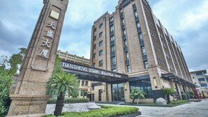 Un hotel moderno con una entrada destacada y un gran monumento de piedra.