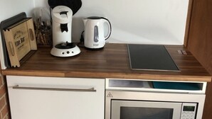 Cozinha equipada com cafeteira, chaleira e micro-ondas.