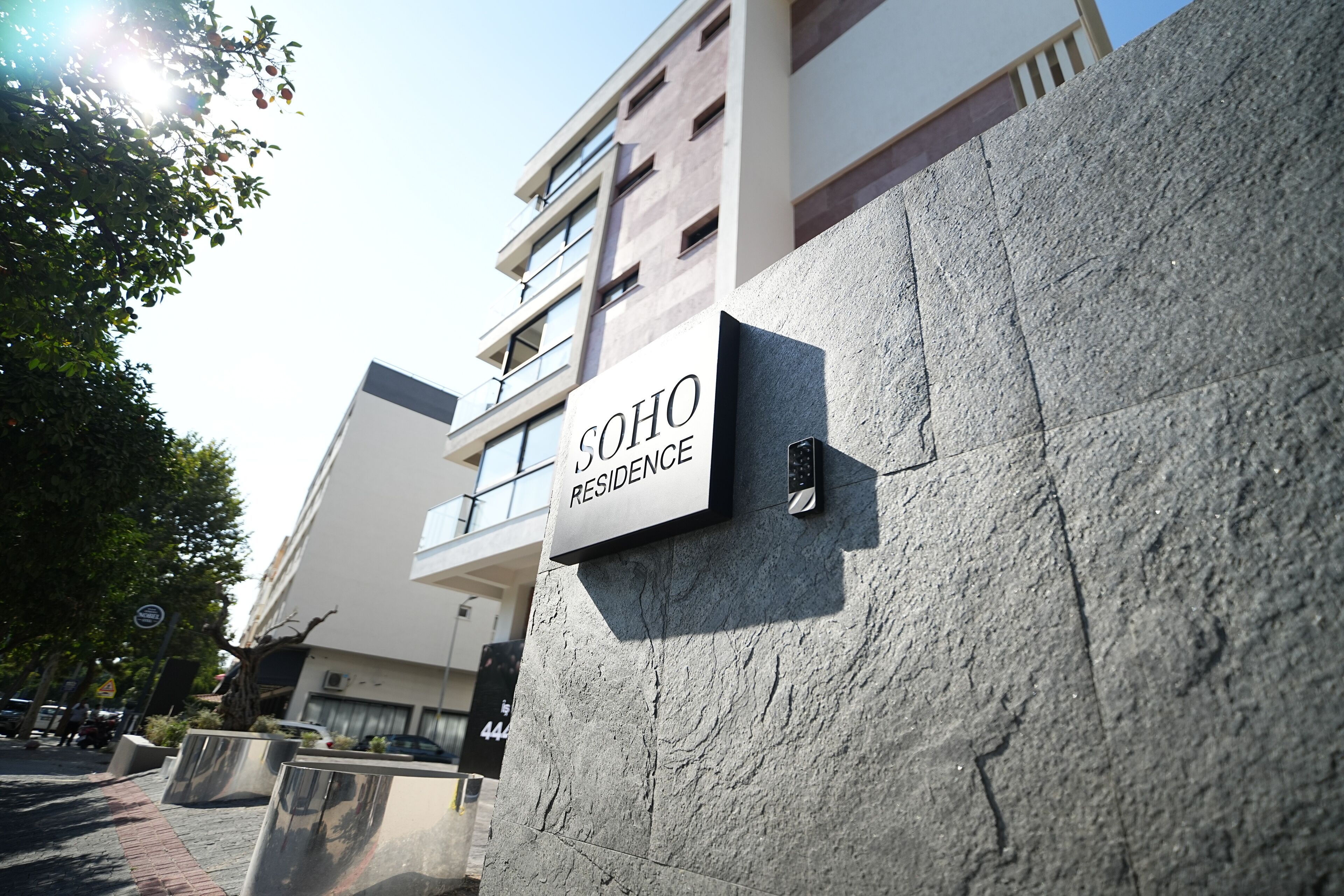 A building with a sign reading "SOHO RESIDENCE".