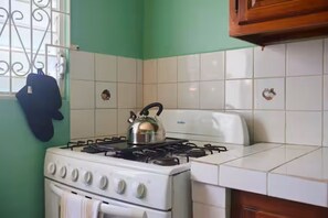 A kitchen with a gas stove, a kettle, and a toaster. - Roseau Escape | 2BR | Free Parking | Sleeps 4 (Roseau)