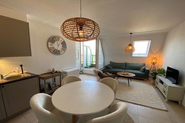 A modern living space with a kitchen, dining area, and seating area.
