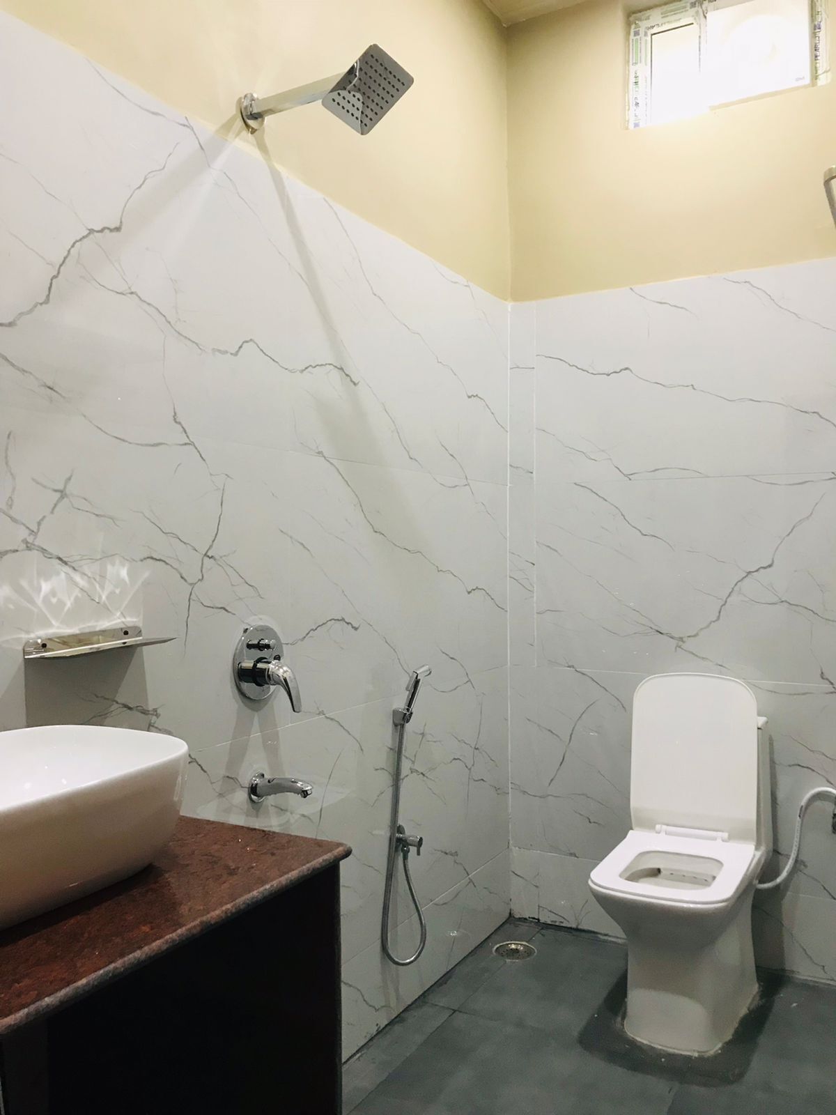 A bathroom with a white toilet, a sink, and a shower.