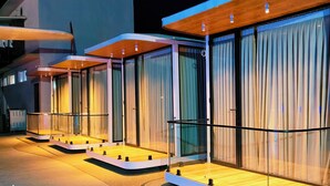 Un hotel moderno con amplios ventanales de vidrio, balcones de madera y un diseño limpio y contemporáneo.