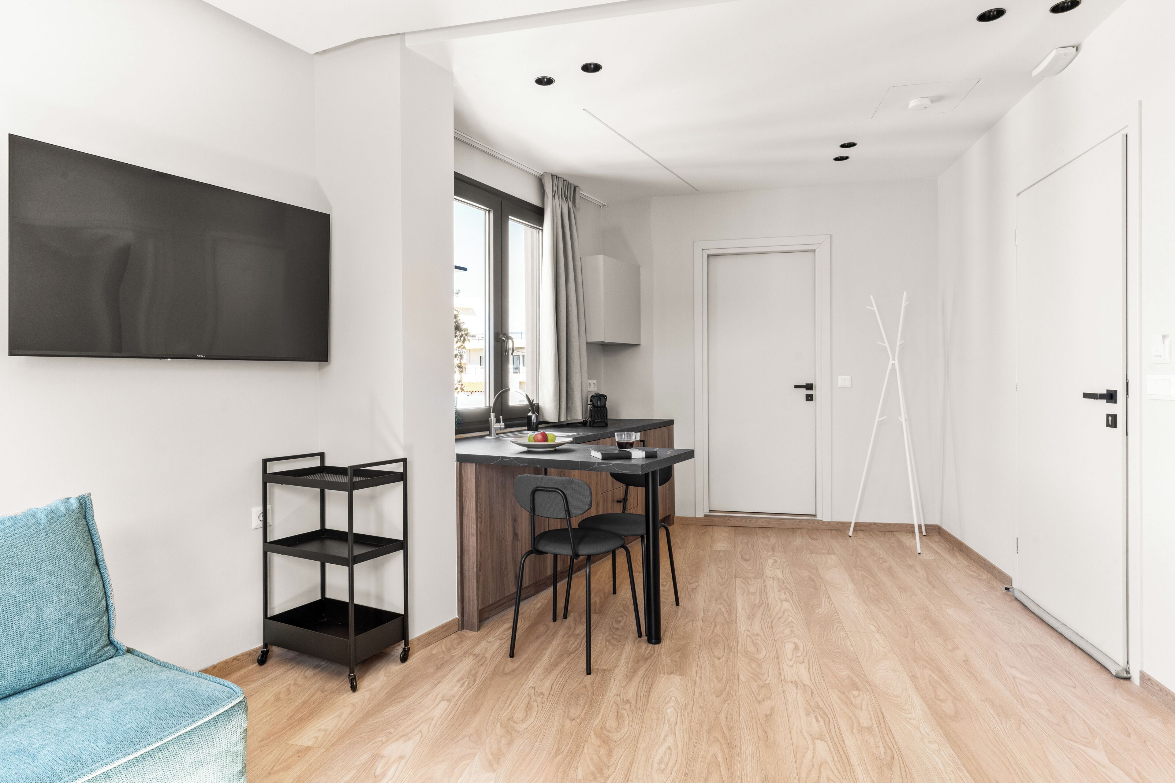 Een moderne keuken met een eethoek, een flatscreen-televisie en een zithoekje.