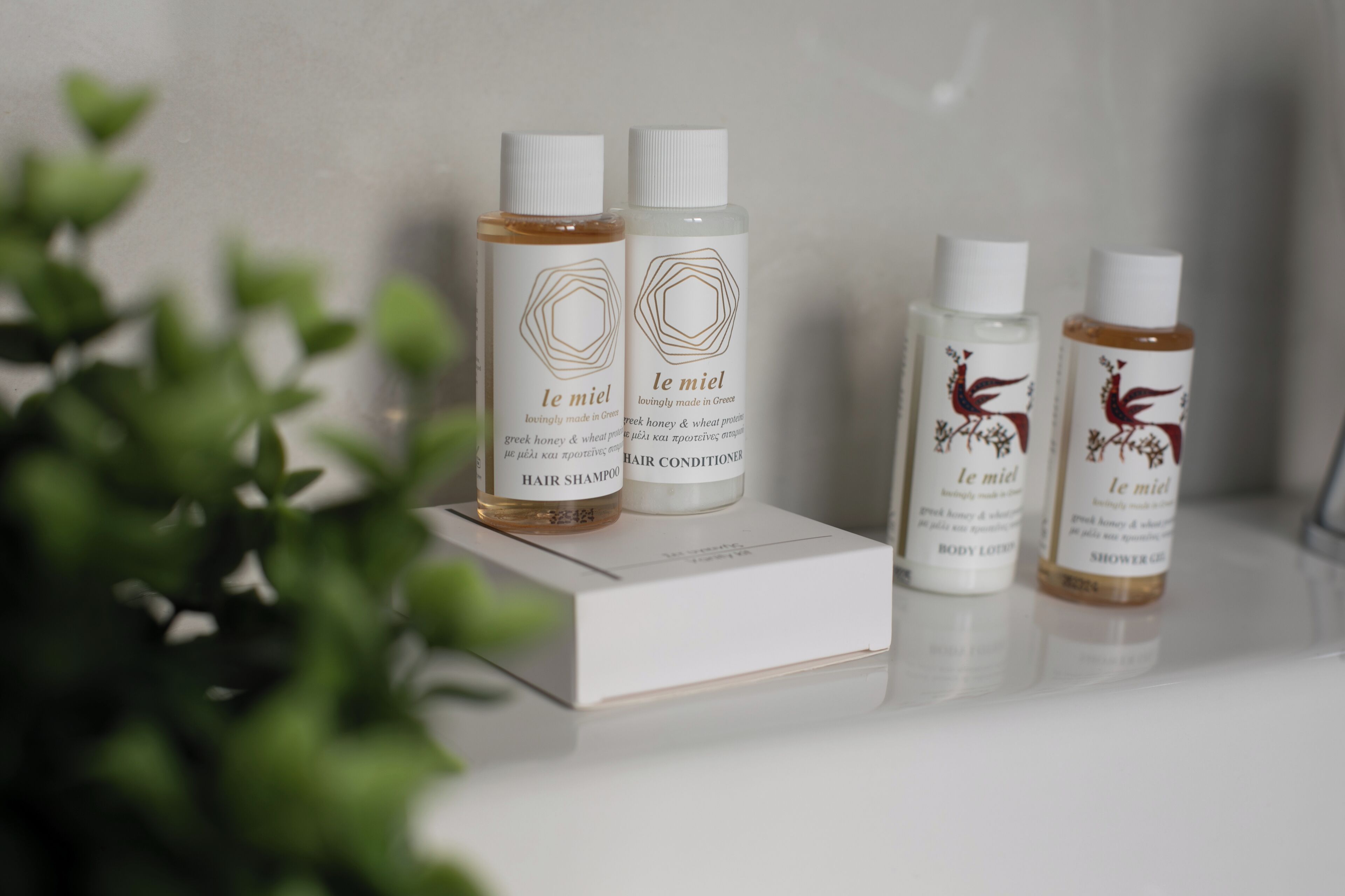 Quatre flacons de produits capillaires de la marque « Le Miel » sur une boîte blanche.