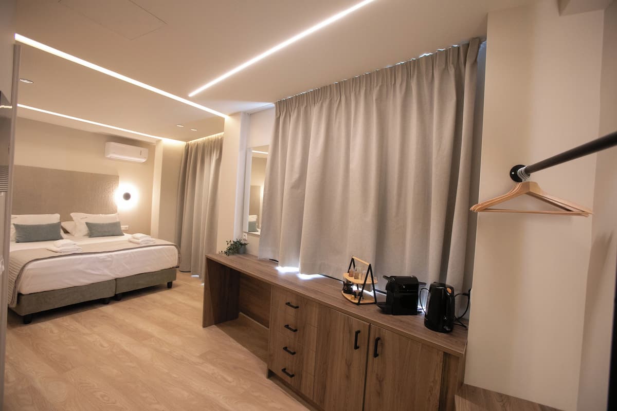 A modern bedroom with a bed, bedside table, and a hanging coat rack.