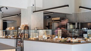 A bakery counter with various baked goods, a glass display case, and a modern interior design. - Bedspot Heraklion (Heraklion)