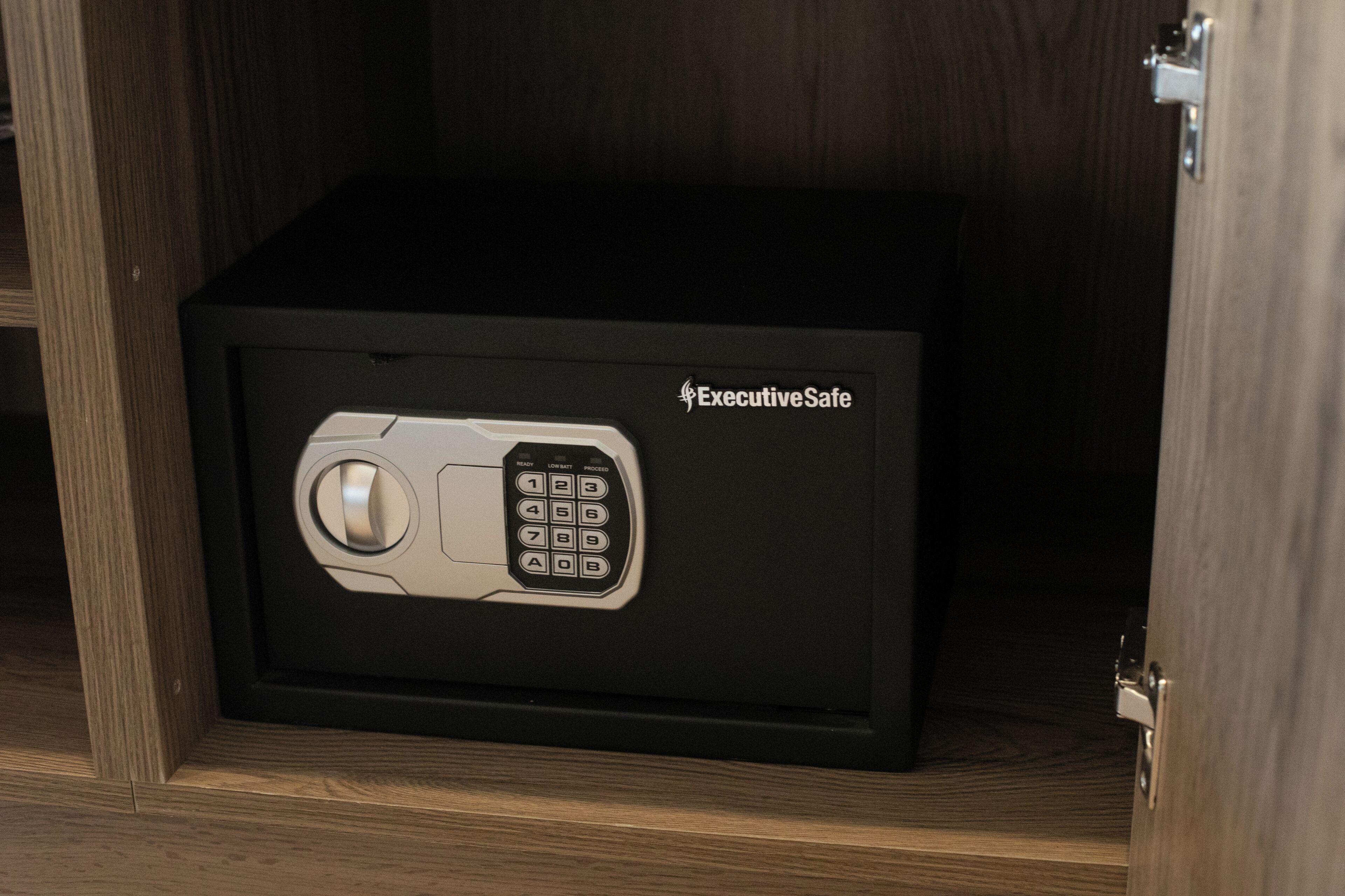 A black safe with a keypad and the label "ExecutiveSafe" on a wooden cabinet.