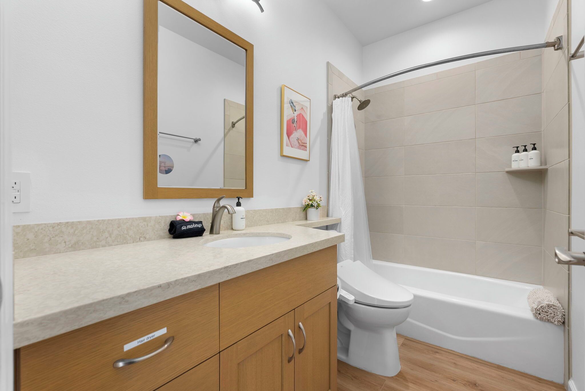 A modern bathroom with a sink, toilet, and shower area.