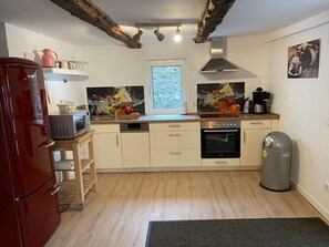 Una cocina moderna con refrigerador, horno, pileta y ventana.