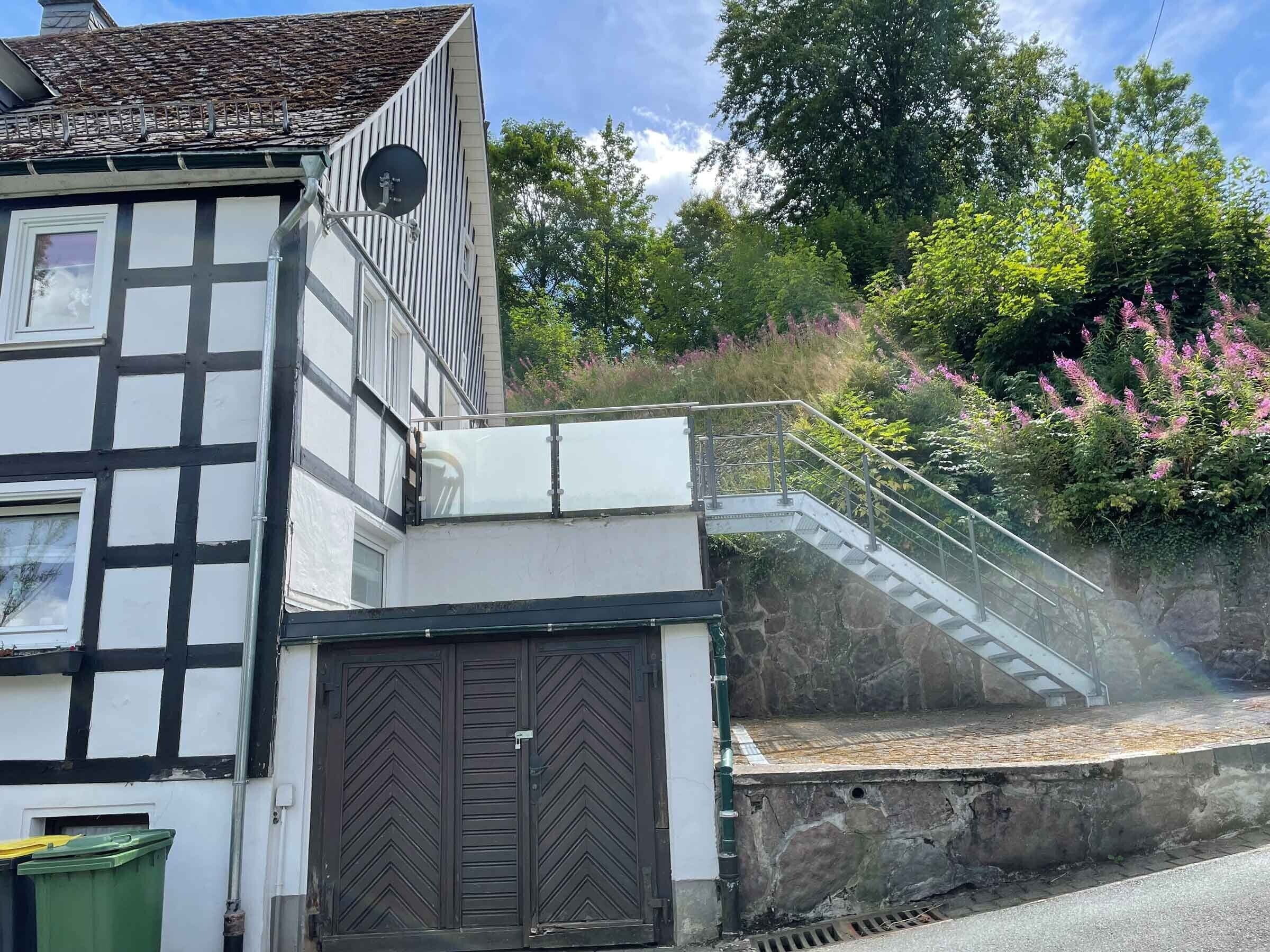 Ein traditionelles Fachwerkhäuschen mit einer breiten Tür und einem kleinen Fenster.