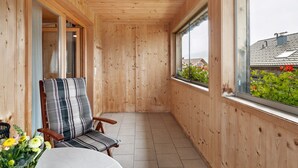 A wooden interior corridor with a window, a chair, and a table. - Room 'Bergblick' with Mountain View, Shared Garden and Wi-Fi (Sibratsgfäll)