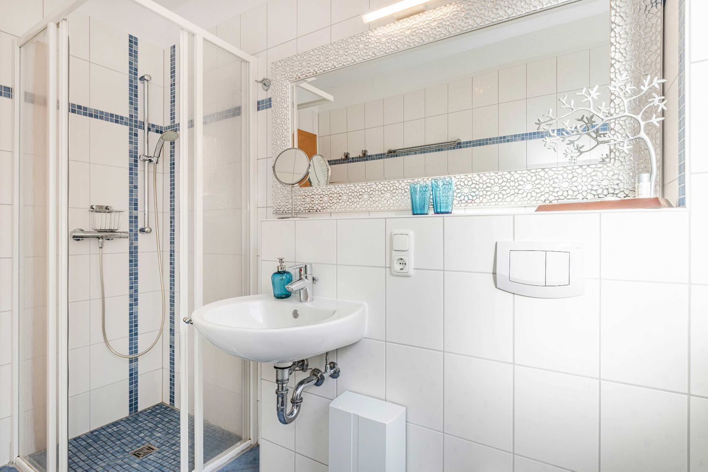 A bathroom with a shower, sink, and mirror.
