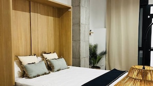 Un dormitorio moderno con una cama grande, un armario de madera y una lámpara original.