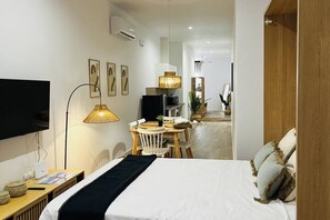 A hotel room with a bed, a desk, a chair, a TV, and a lamp. - Travel Habitat Mediterranean Suites 8 (València)