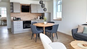 A modern kitchen with a central island, built-in appliances, and pendant lighting. - Harbor master Lasse - Spacious, cozy & maritime above the rooftops of (Sassnitz)