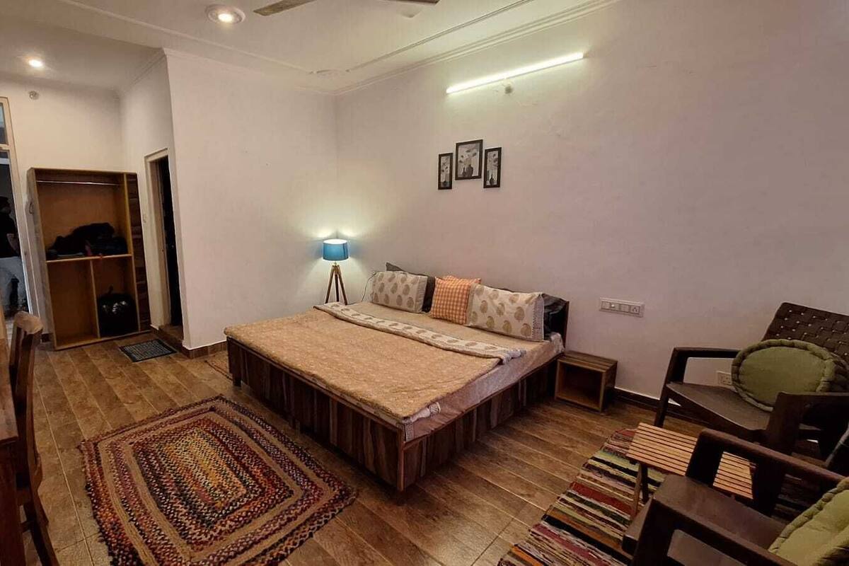 Une chambre à coucher comprenant un lit, une table de chevet, une lampe et une armoire.