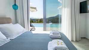 A modern hotel room with a bed, a view of a pool, and a mountain landscape. - Unparalleled comfort and tranquility with stunning Ionian sea views in Lefkada (Lefkada)