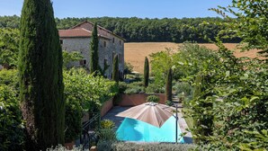 A stone house with a swimming pool, surrounded by greenery and a clear sky. - Mas Combefa, a haven of serenity between history and nature. (Combefa)