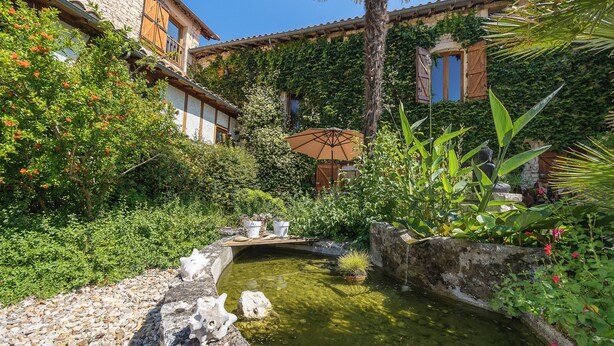 A courtyard with a small pond, stone pathway, and lush greenery. - Mas Combefa, a haven of serenity between history and nature. (Combefa)