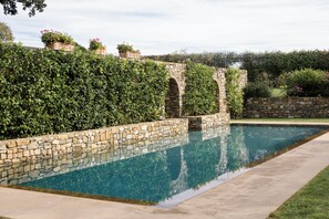 Ein Schwimmbecken mit Steinmauern und einer Steinkonstruktion.