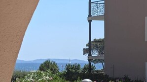 Um edifício com varanda e vista para um jardim cheio de plantas e flores.