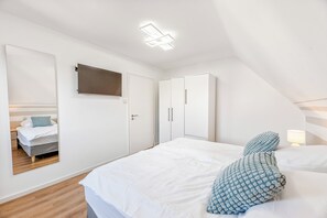 2 habitaciones, escritorio y tabla de planchar con plancha