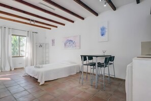 A room with a bed, a table with chairs, and artwork on the walls. - Villa 'Guadiaro' with Mountain View, Wi-Fi and Air Conditioning (Marbella)