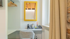 A compact kitchen with a wooden ceiling, a small window with beige curtains, a white chair, and a radiator. - ApartmentsArena - Mustacchi Rooms (Verona)