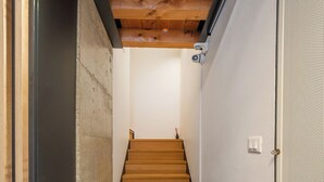 A narrow hallway with a wooden staircase leading to a room. - ApartmentsArena - Mustacchi Rooms (Verona)