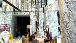 A marble lobby with a central seating area, a chandelier, and a sign for backpacker day/week rental. - Octopus Suite on  HighRise, Skytrain, Fast Wifi and AC (Krung Thep Maha Nakhon)