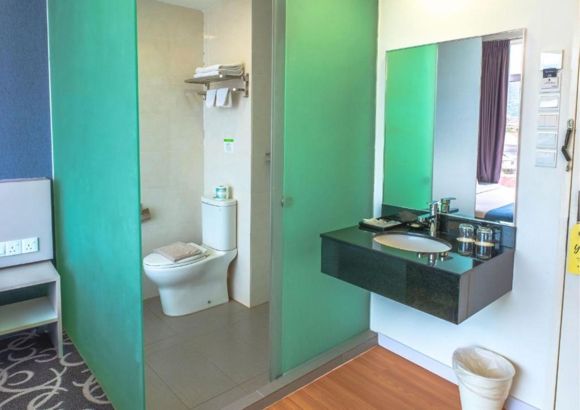 Een badkamer met toilet, wastafel en spiegel.