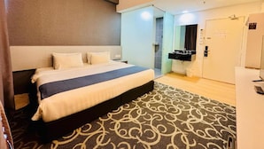 Una habitación de hotel con cama, baño y minibar.